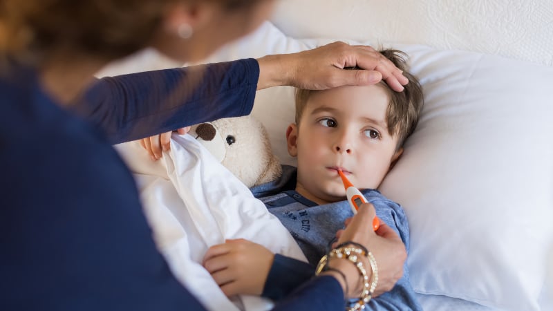 A mother checks her small boy for fever