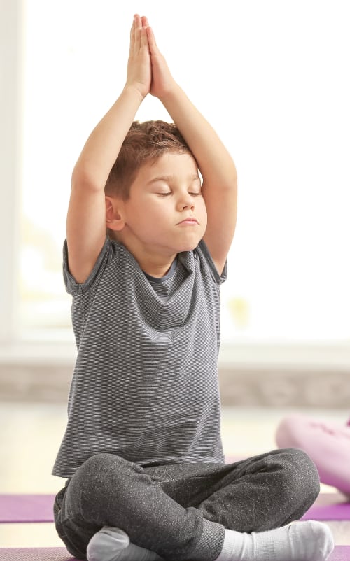 A boy holds a yoga pose