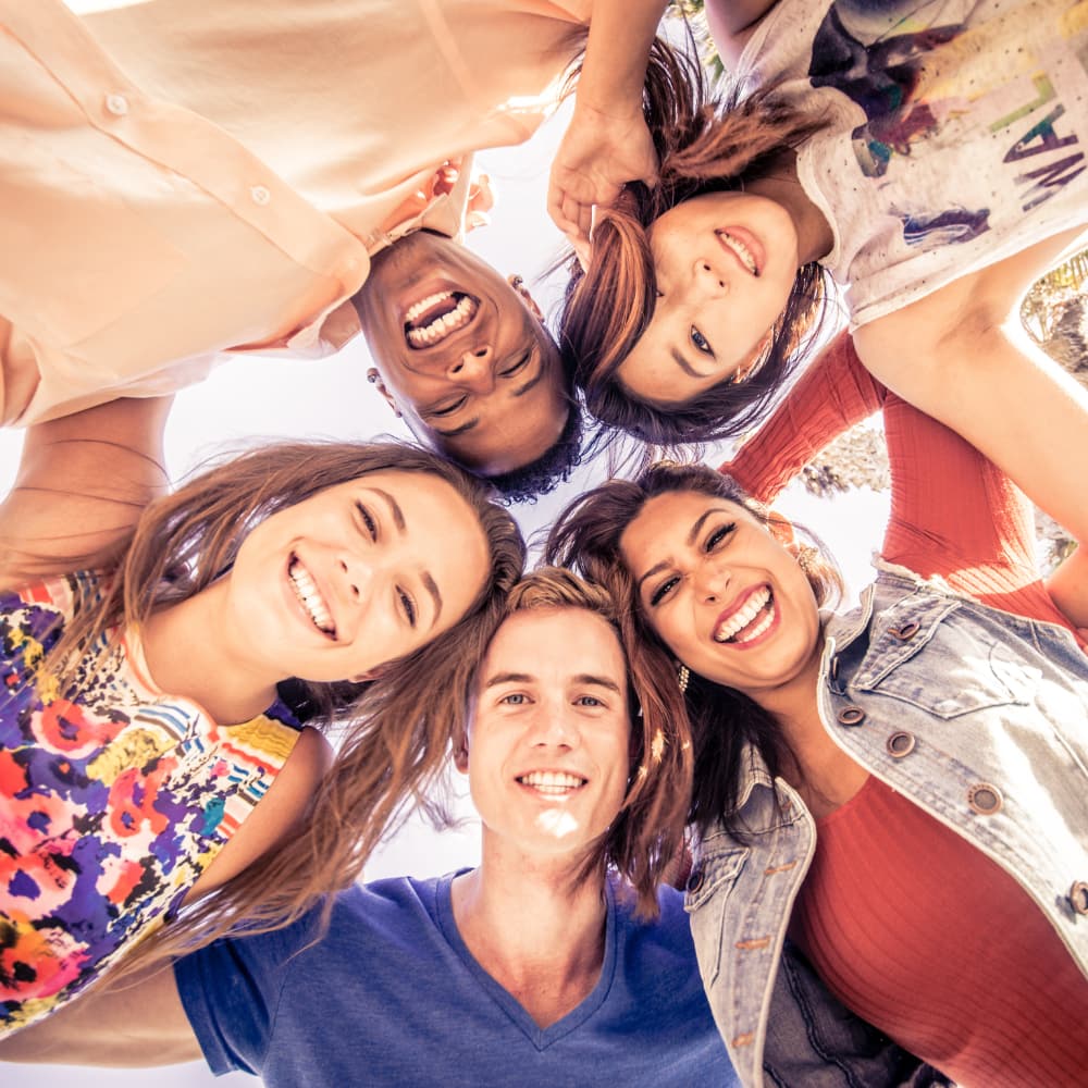 A group of teens take a smiling selfie